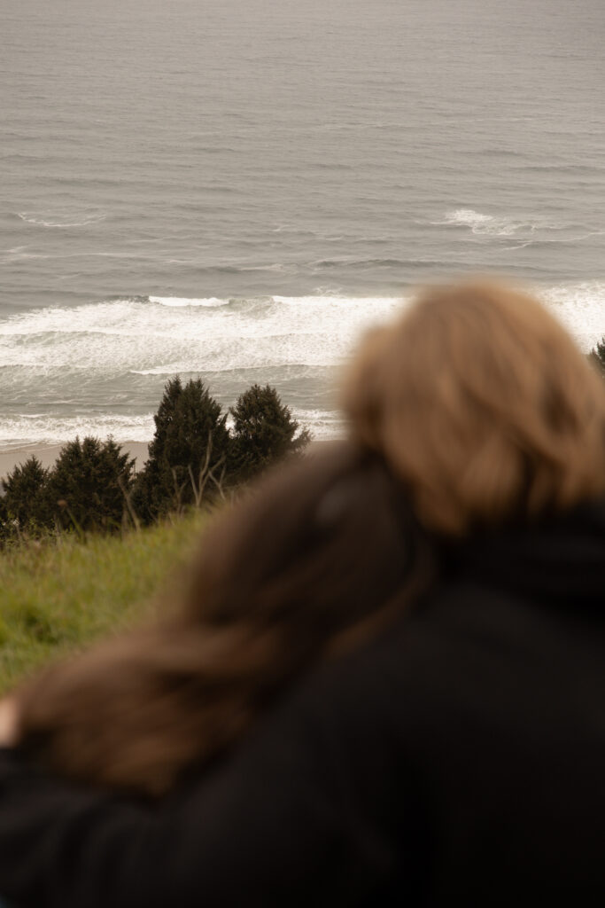 Engaged couple looking at the ocean taken by Oregon engagement photographer.