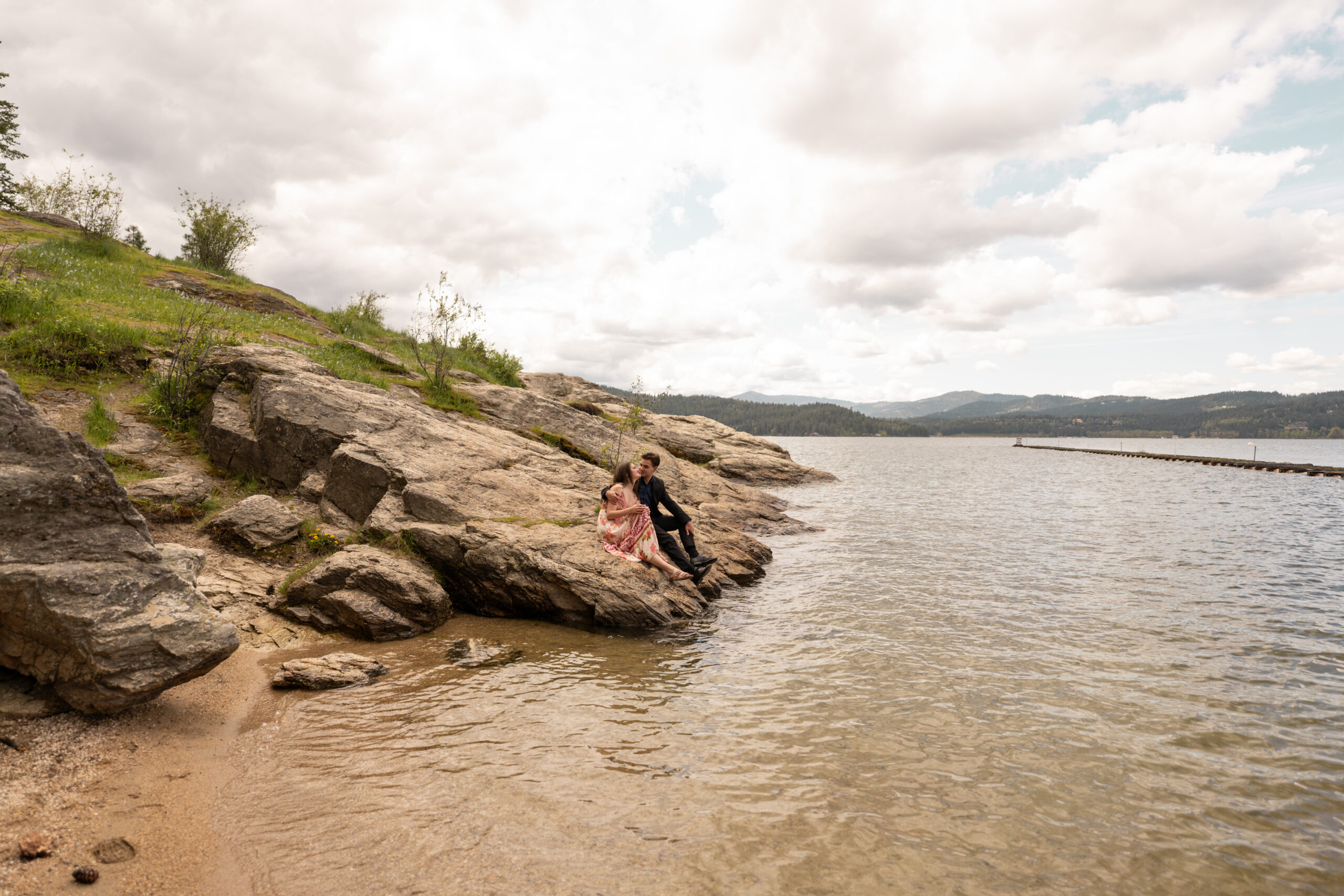 Engaged couple sitting on rocks taken by photographers in Idaho