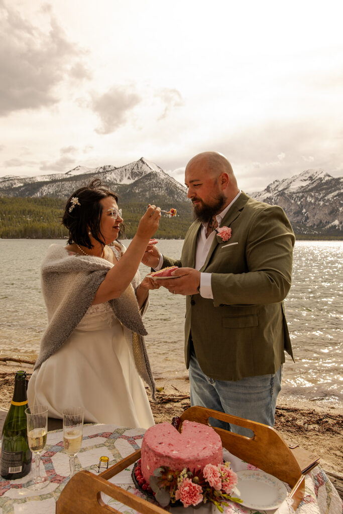 Best Places to Elope in Idaho | | Love in the Hills Photo & Video Newlyweds cutting cake by the lake in one of the best places to elope in Idaho.
