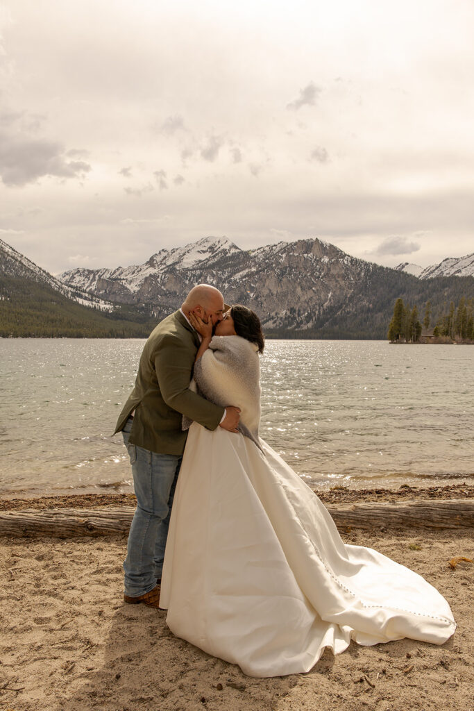 Best Places to Elope in Idaho | | Love in the Hills Photo & Video Couple kissing by a mountain lake in one of the best places to elope in Idaho.