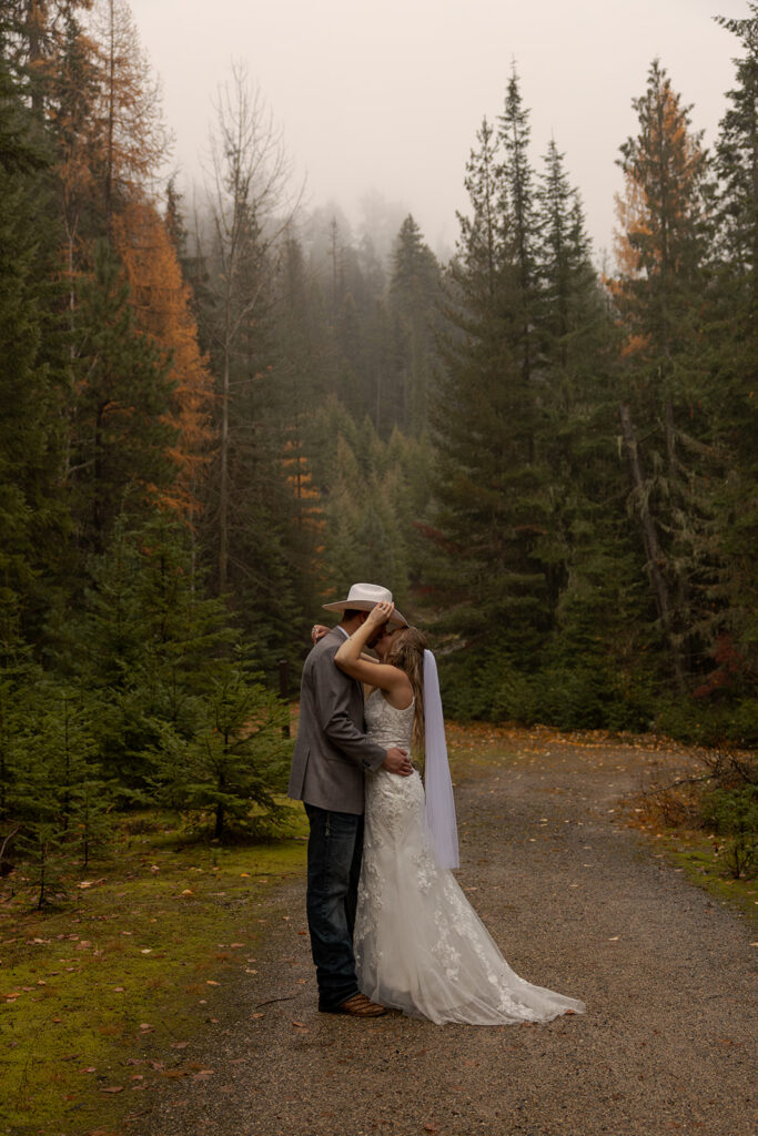 Idaho Elopement Locations | Love in the Hills Photo & Video Couple kissing on a quiet forest road surrounded by a scenic Idaho elopement location.