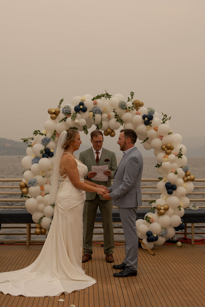 Places to Elope in Idaho | Love in the Hills Photo & Video Couple exchanging vows on a lakeside deck in one of the best places to elope in Idaho.