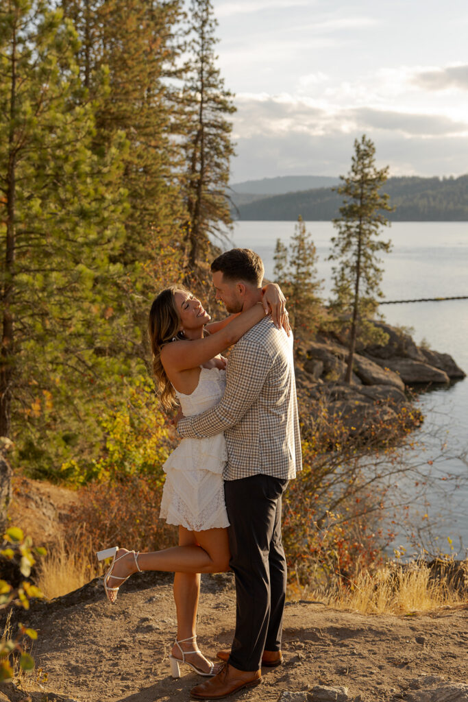 Places to Elope in Idaho | Love in the Hills Photo & Video Couple embracing on a rocky overlook above the lake in one of the best places to elope in Idaho.