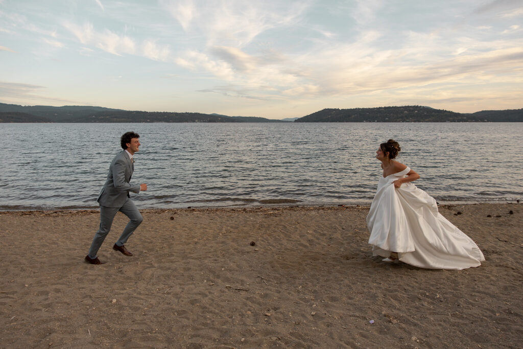 Bride and groom run to each other passionately in front of a lake at their Idaho elopement