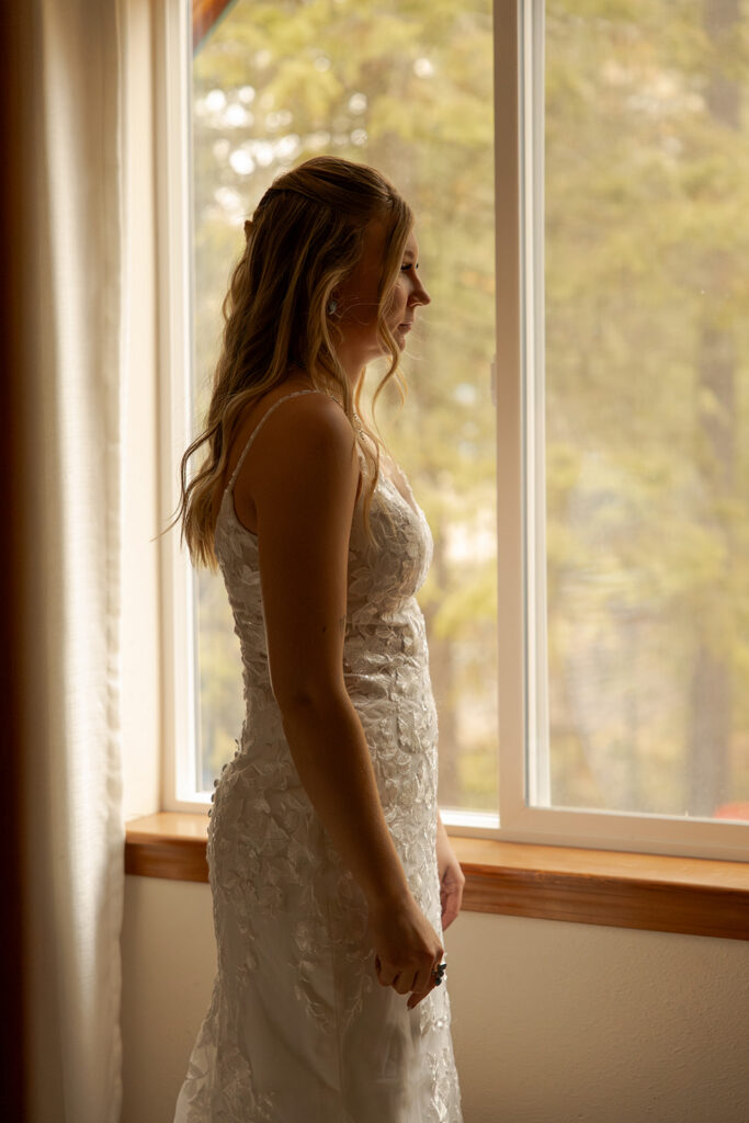 Priest Lake Wedding | Love In The Hills Photo And Video Bride getting ready by the window before her Priest Lake wedding.